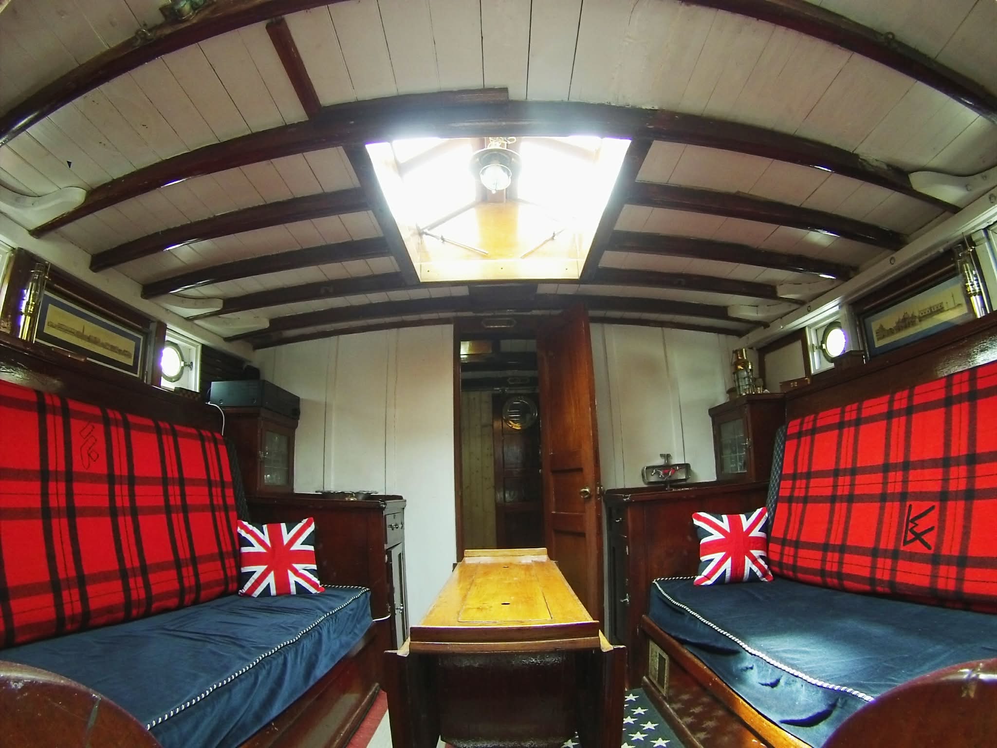 Carré central du Davia avec banquettes tartan rouge et coussins Union Jack